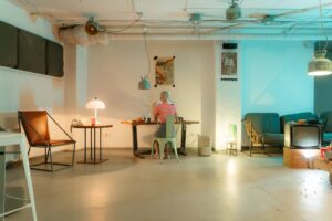 A woman working at a desk in a stylish, retro-inspired room with ambient lighting.