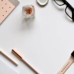 Stylish rose gold themed flatlay featuring office supplies and a smartwatch on a white background.